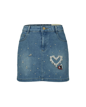Blue denim skirt with decorative heart and gemstones on a white background