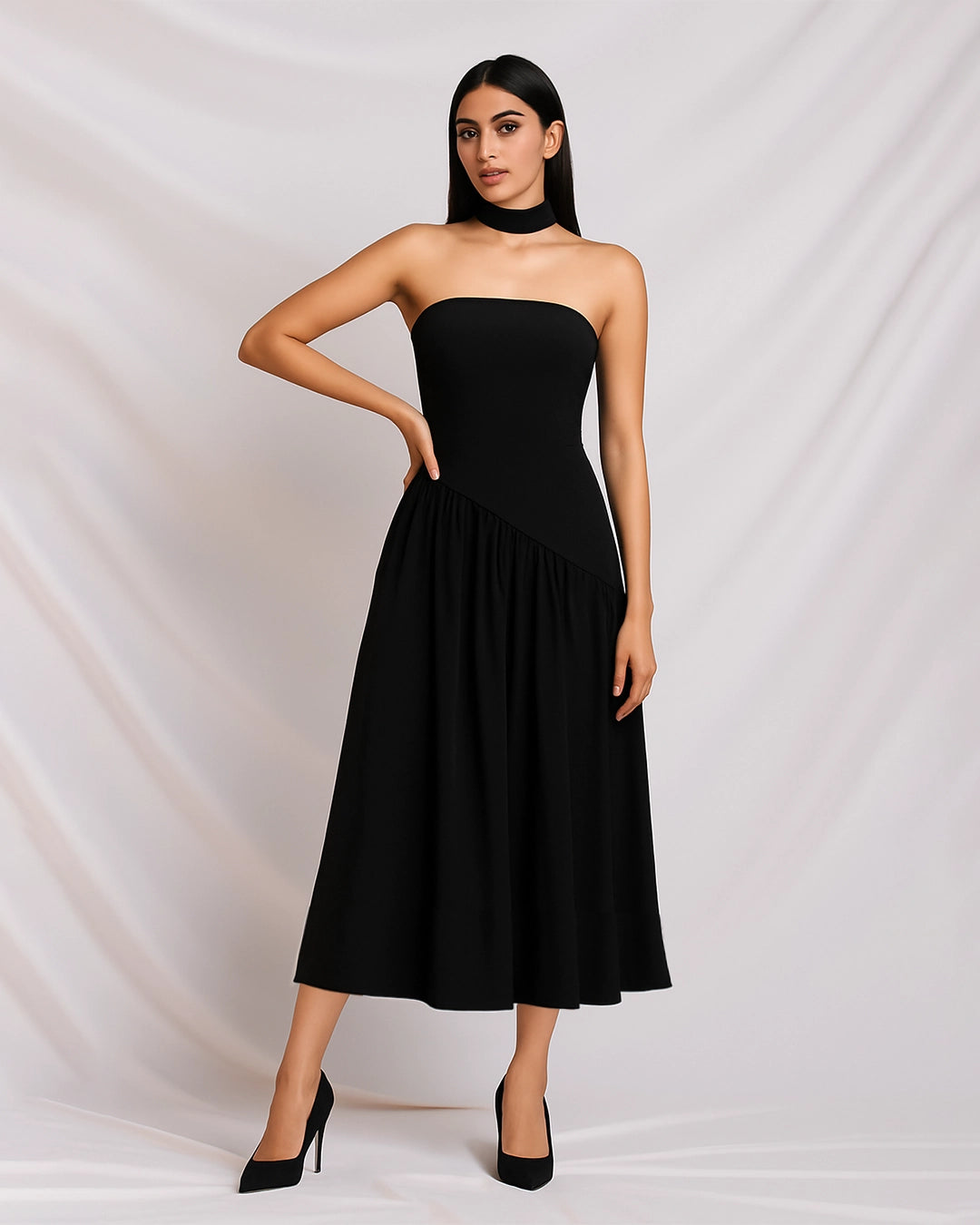 Woman wearing a black strapless dress against a white background