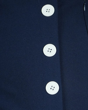Close-up of a navy blue garment with white buttons