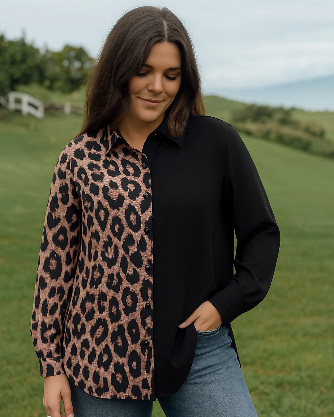 Woman wearing a black shirt over a leopard print cardigan in a grassy outdoor setting