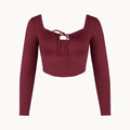 Maroon long-sleeve top with a tie detail on a white background