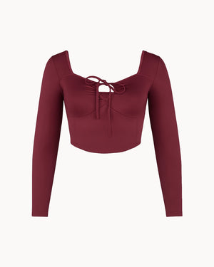 Maroon long-sleeve top with a tie detail on a white background