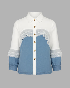 White shirt with blue denim panel and lace details on a gray background
