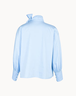 Light blue blouse with a bow detail on the back against a white background