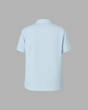 Light blue polo shirt on a gray background