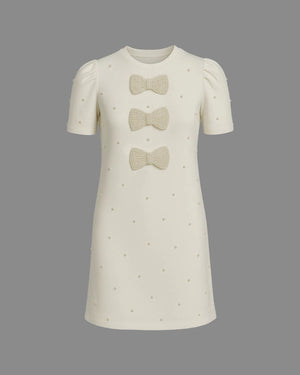 White dress with bow details on a gray background