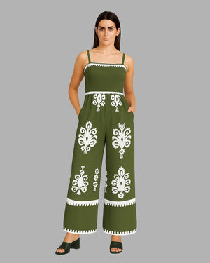 Woman wearing a green jumpsuit with white patterns on a gray background