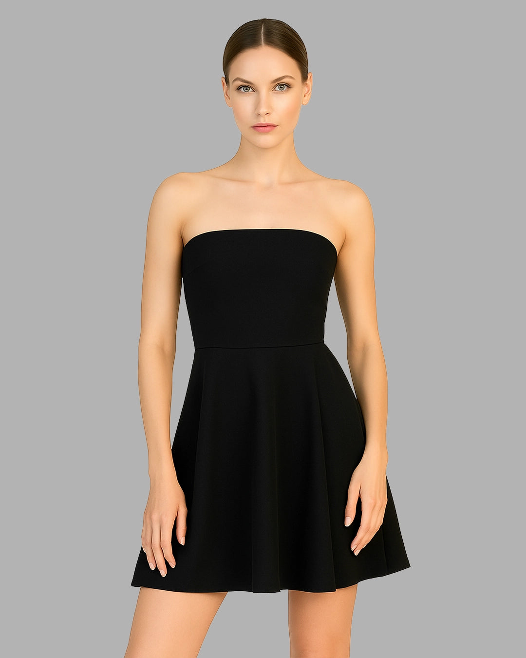 Black strapless dress worn by a model on a gray background