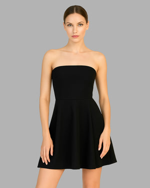Black strapless dress worn by a model on a gray background