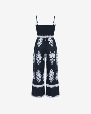 Navy blue jumpsuit with white floral patterns on a white background