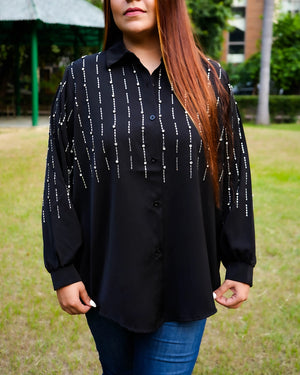 Person wearing a black patterned shirt outdoors
