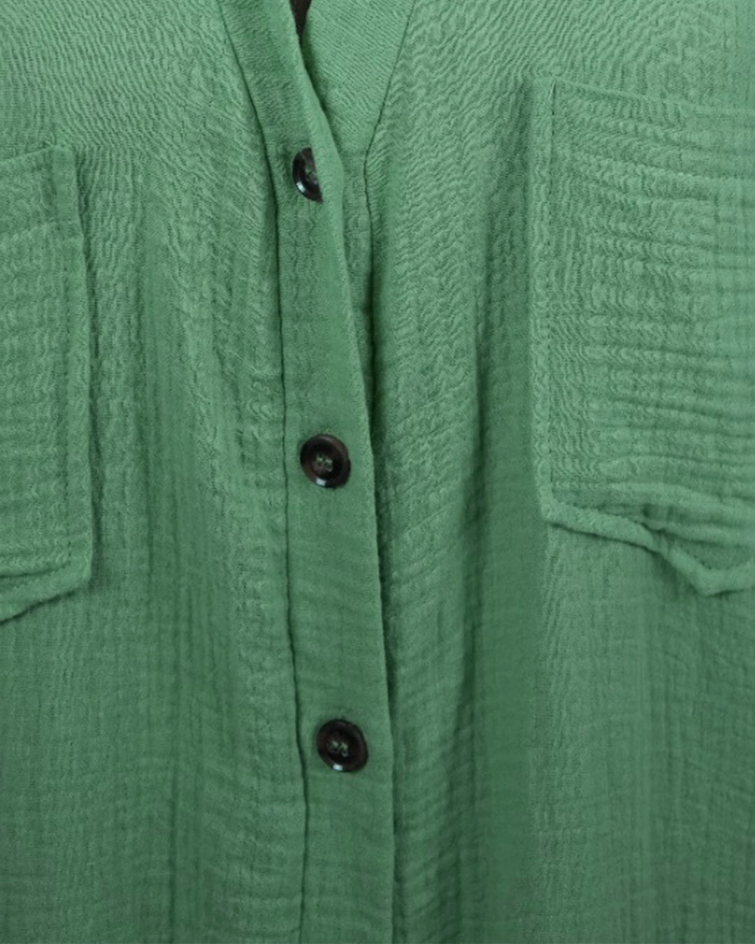 Close-up of a green textured shirt with buttons
