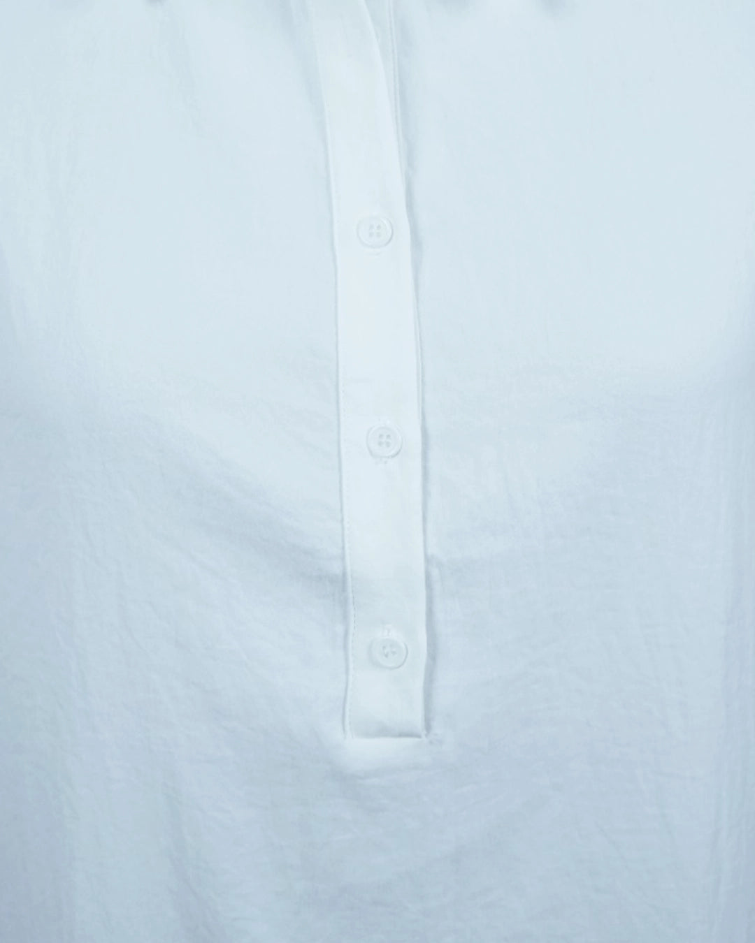 Close-up of a light blue shirt with button details on a white background