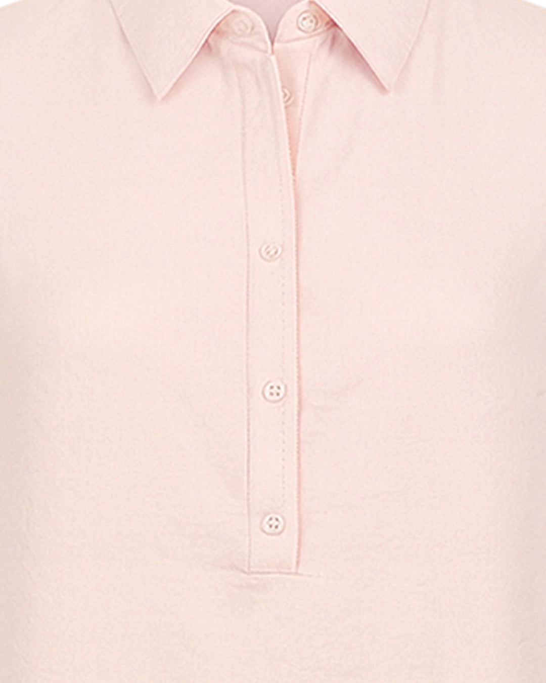 Close-up of a light pink shirt with button details on a white background