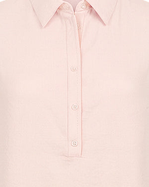 Close-up of a light pink shirt with button details on a white background