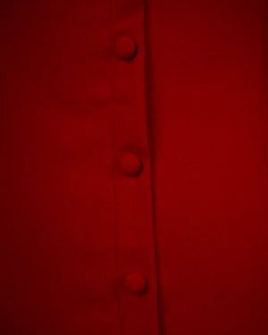 Close-up of a red fabric with buttons on a dark background