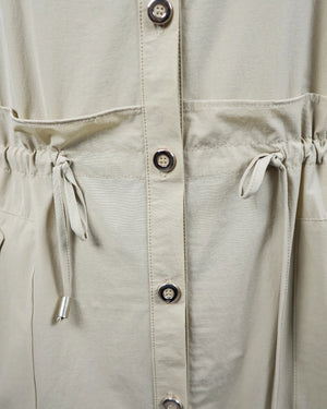 Close-up of a beige jacket with button details and drawstring waist.