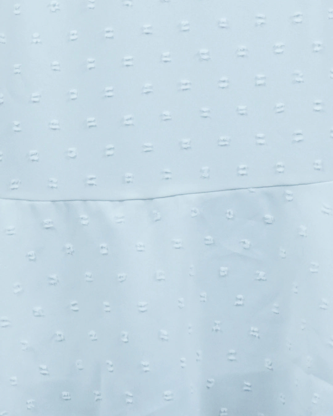 Close-up of light blue fabric with a subtle pattern