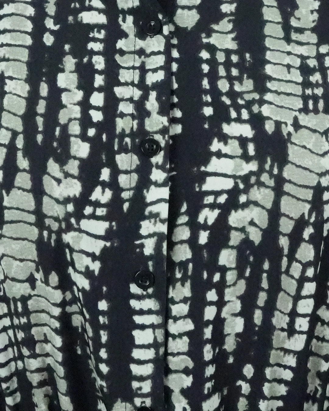 Close-up of a shirt with a black and white abstract pattern