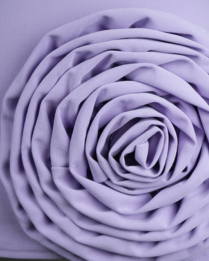 Close-up of a purple fabric flower on a matching purple background