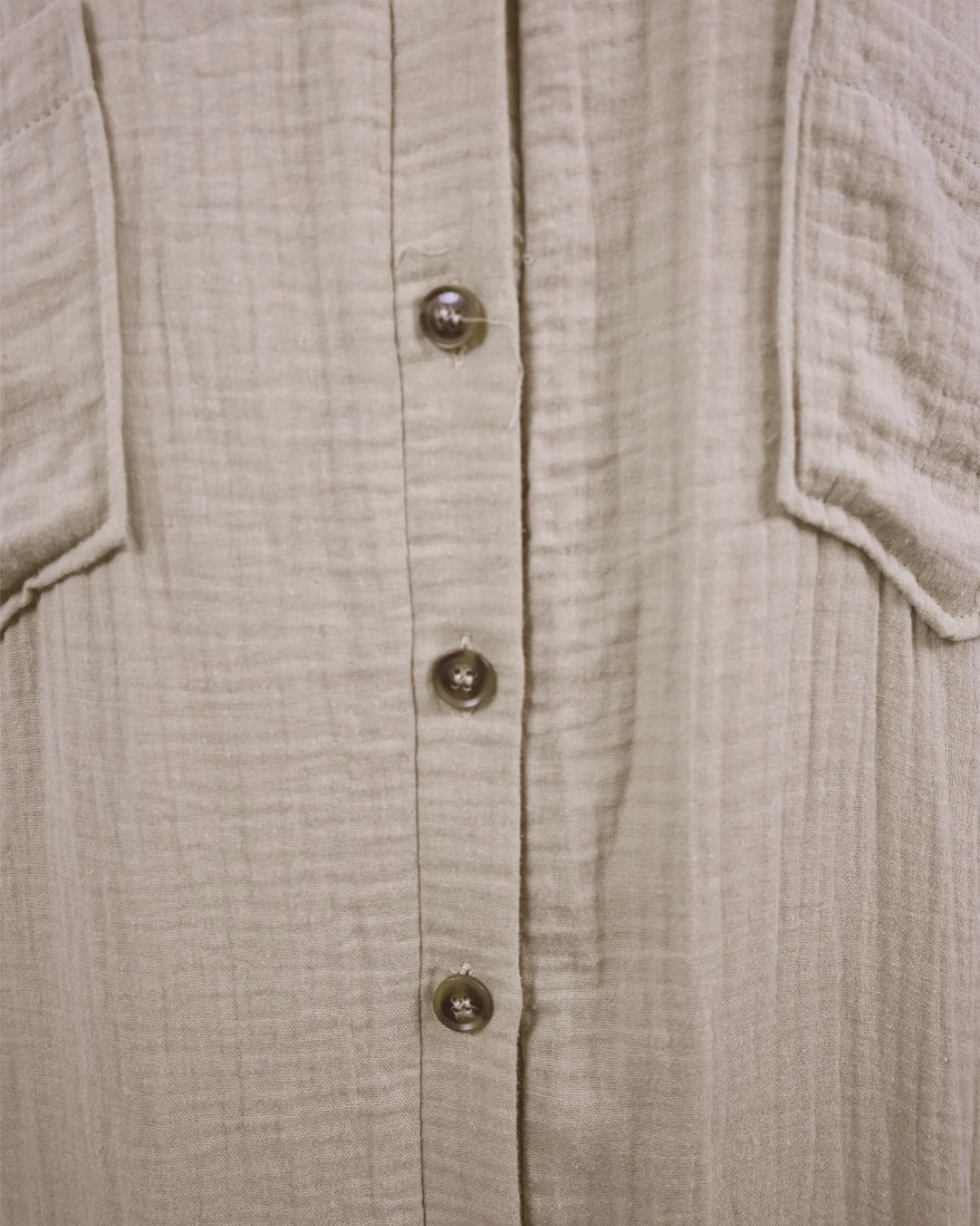 Close-up of a beige textured shirt with buttons