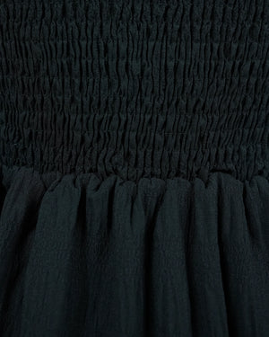 Close-up of dark green fabric with smocked waistband