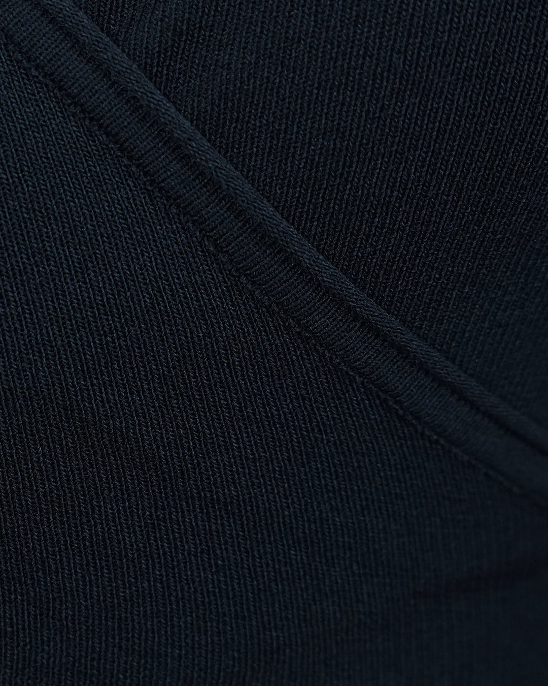 Close-up of dark blue fabric with a visible seam
