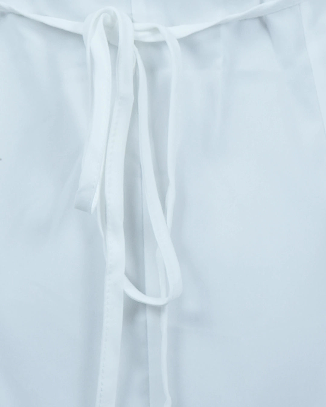 White blouse with tie details on a light gray background