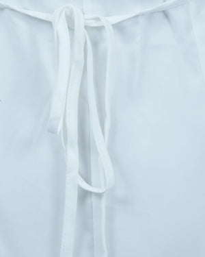 White blouse with tie details on a light gray background