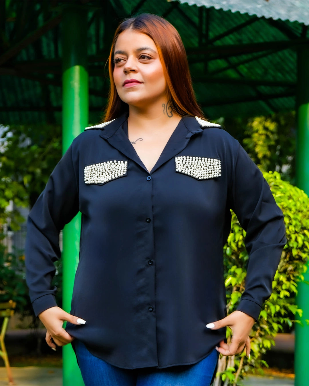 Woman wearing a black shirt with decorative elements in an outdoor setting
