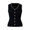 Black sleeveless top with pearl buttons on a white background