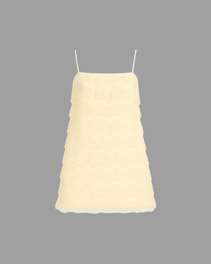 Light yellow dress with thin straps on a gray background