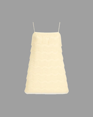 Light yellow dress with thin straps on a gray background