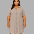 Woman wearing a beige button-up dress against a gray background