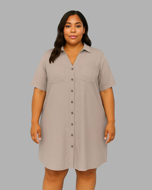Woman wearing a beige button-up dress against a gray background