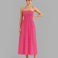 Woman wearing a strapless pink dress on a gray background