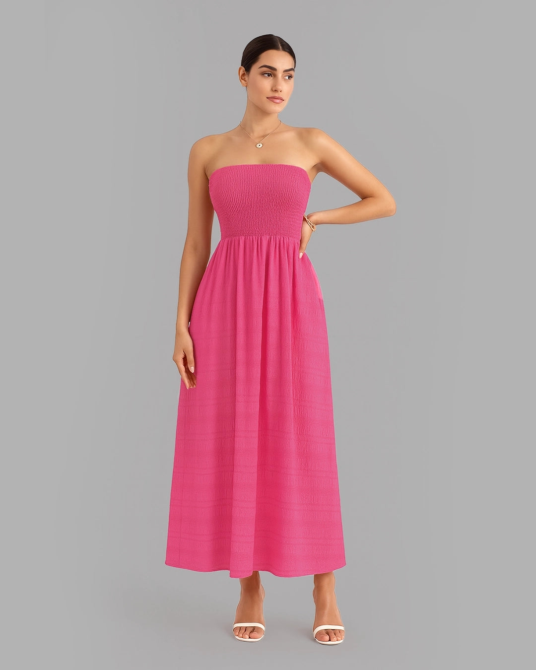 Woman wearing a strapless pink dress on a gray background