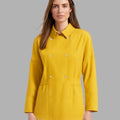 Woman wearing a yellow jacket against a gray background