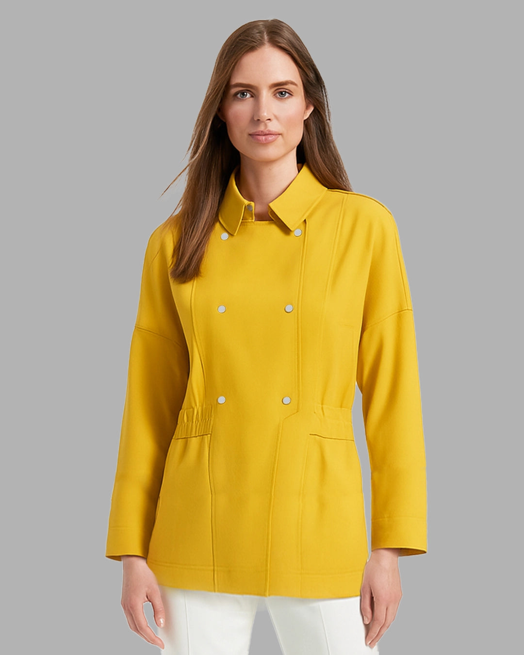 Woman wearing a yellow jacket against a gray background