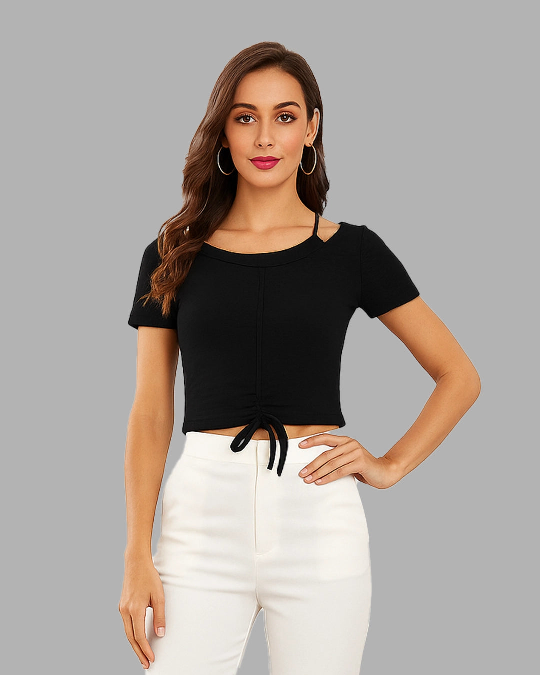 Woman wearing a black crop top and white pants on a gray background