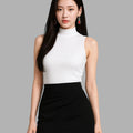 Woman wearing a white sleeveless top and black skirt on a gray background