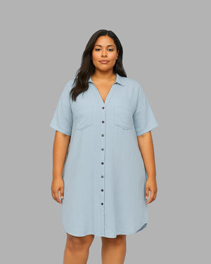 Woman wearing a light blue dress against a gray background
