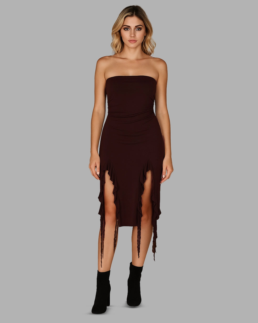 Woman wearing a strapless brown dress with a slit on a gray background