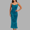 Woman wearing a teal dress against a gray background