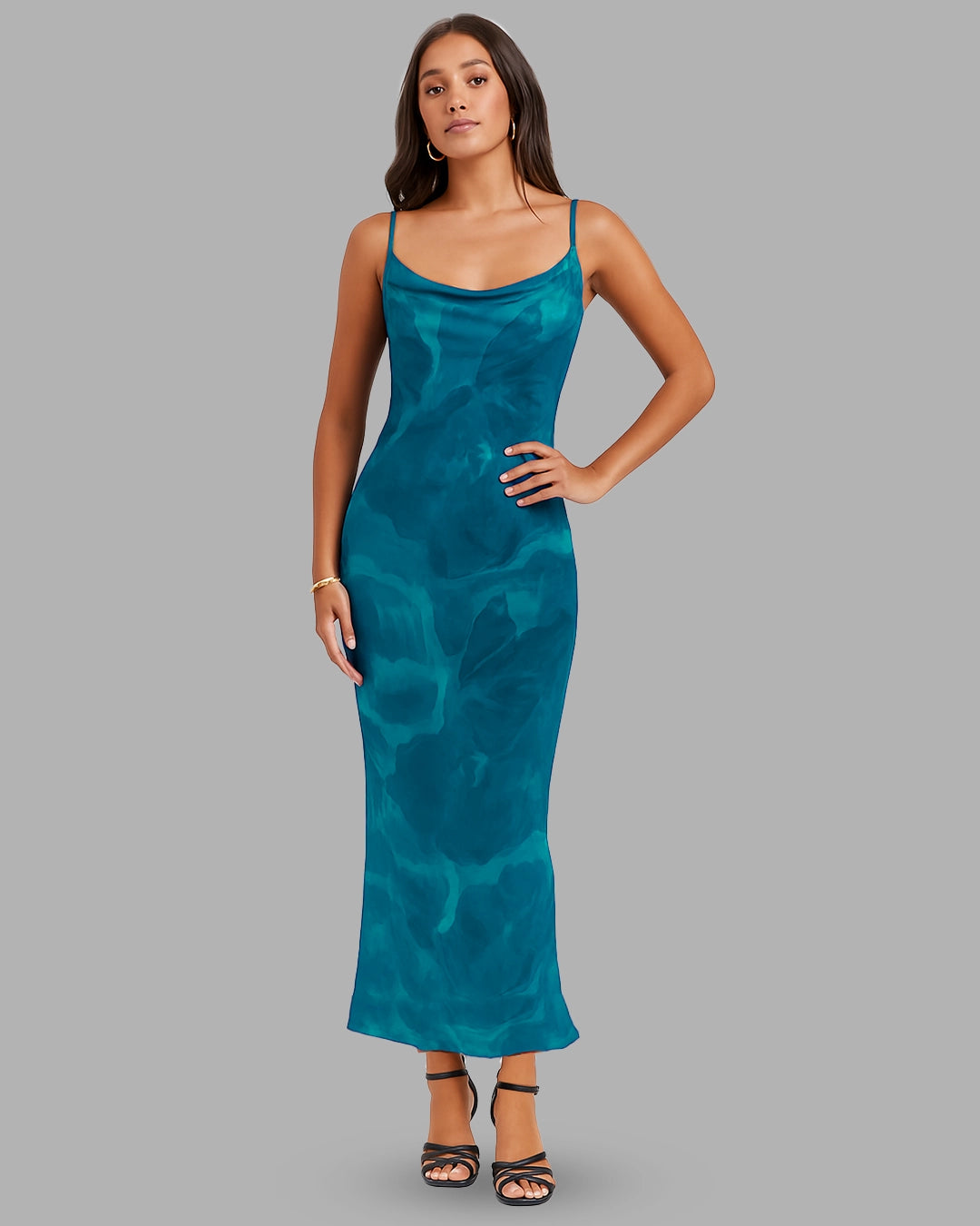 Woman wearing a teal dress against a gray background