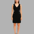 Woman wearing a black dress with white accents on a gray background