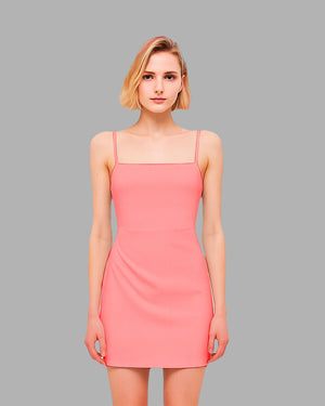 Woman wearing a pink dress against a gray background