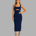 Woman wearing a navy blue dress with cut-out design on a gray background