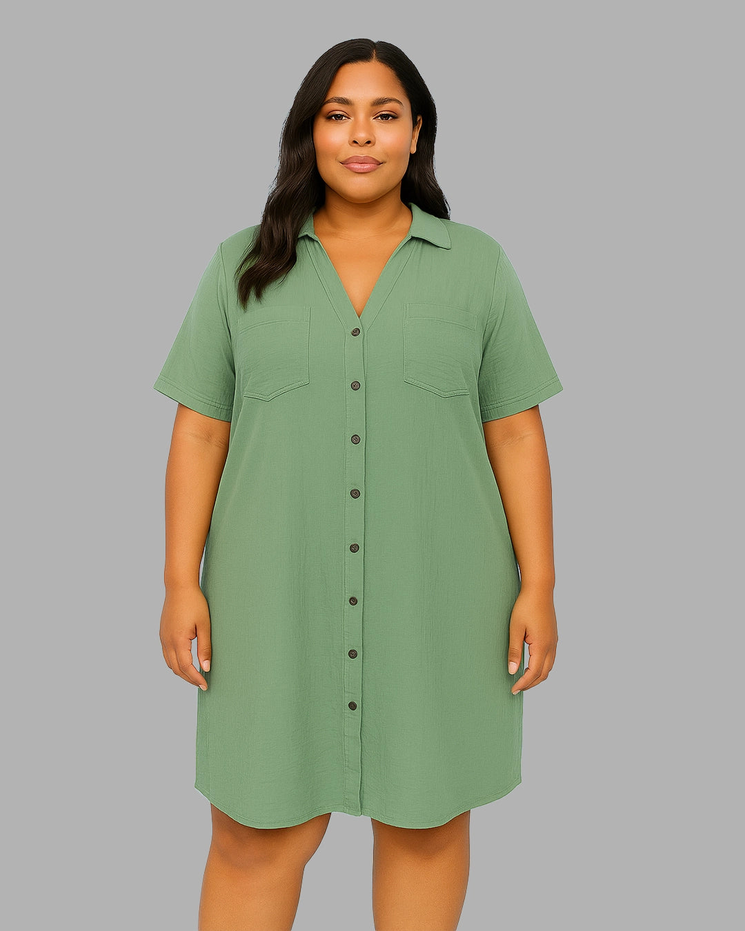 Woman wearing a green shirt dress against a gray background