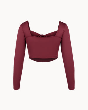Maroon long-sleeve crop top on a white background